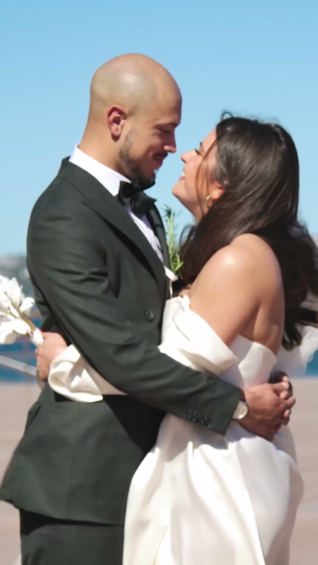 Tiana & Adrian. Thirty seconds, shot portrait. Opens on the couple's names over a church interior, then the Opera House, The Rocks, a ring macro with red nails, olive trees, a bouquet thrown out against the Harbour Bridge, and a blown-out black-and-white embrace.